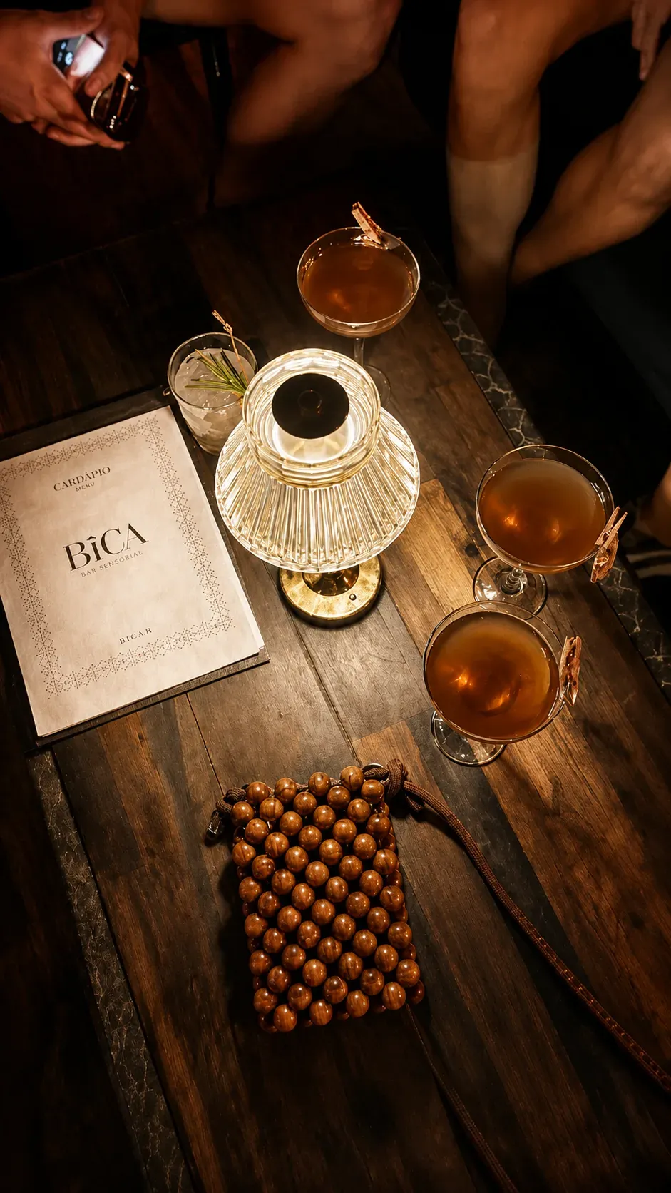 Mesa do BICA BAR à luz de velas com coquetéis autorais servidos, pronta para receber os clientes